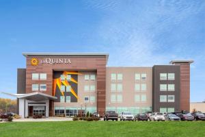 a hotel with cars parked outside of a building at La Quinta Inn & Suites by Wyndham Shorewood in Shorewood