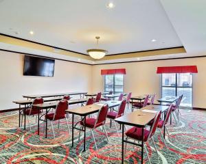 a conference room with tables and chairs and a flat screen tv at Comfort Suites Uniontown in Uniontown