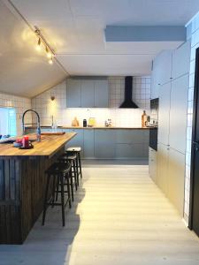 uma grande cozinha com um balcão de madeira e bancos em Skars Lodge / North Mountain Lodge em Funäsdalen