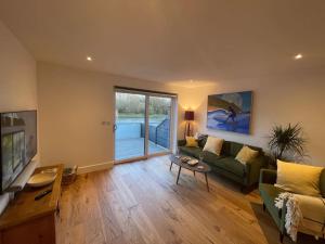 a living room with a couch and a table at Canalside Bude in Bude