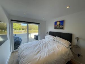 a bedroom with a bed and a large window at Canalside Bude in Bude