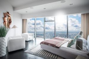sypialnia z łóżkiem typu king-size i dużymi oknami w obiekcie 30th+ Floor Apartments in Sky Tower we Wrocławiu