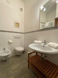 uma casa de banho com um lavatório, um WC e um espelho. em Antica Dimora Leones em Palaia