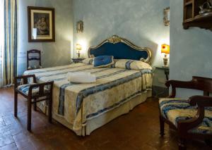 um quarto com uma cama grande e 2 cadeiras em Antica Dimora Leones em Palaia