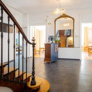 - un salon avec un escalier et un miroir dans l'établissement Berti Hotel - Mulhouse Centre Gare, à Mulhouse