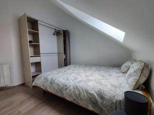 um quarto com uma cama e uma estante de livros em Appartement T3 "YUCA" Hyper centre d'ERNÉE em Ernée