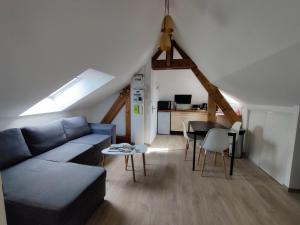uma sala de estar com um sofá azul e uma mesa em Appartement T3 "YUCA" Hyper centre d'ERNÉE em Ernée