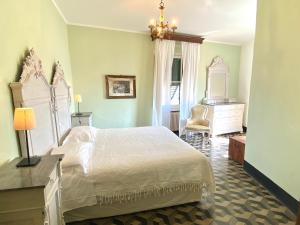 a bedroom with a large white bed and a dresser at AGRITURISMO CASA OLIVIERI in Sestri Levante