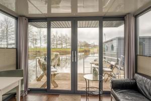 una sala de estar con puertas correderas de cristal en Tiny Hanzeboat, en Hattem