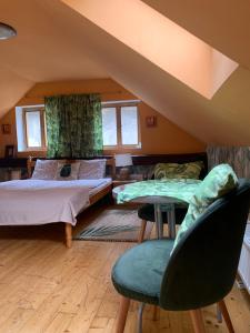 1 dormitorio con 2 camas y sillas en un ático en LOFT Natalya Gold, en Český Krumlov