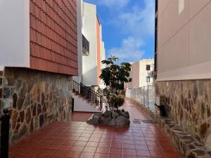 a walkway between two buildings in a city at Holiday House Always Sun in Playa de Santiago
