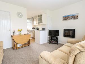 a living room with a couch and a kitchen at 14 Siesta Mar in Norwich