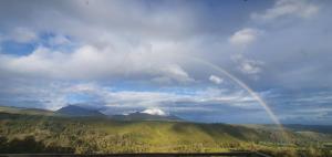 a rainbow in the sky over a mountain at Summer Villa in Mossel Bay