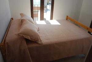 una cama de madera con almohadas en una habitación en Casa Rural Carmen Atzeneta en Adzaneta