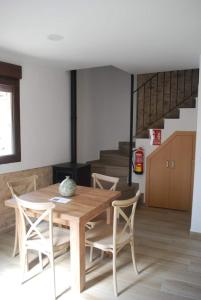 a dining room with a wooden table and chairs at Casa Rural Carmen Atzeneta in Adzaneta