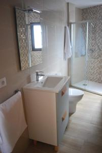 Baño blanco con lavabo y aseo en Casa Rural Carmen Atzeneta en Adzaneta