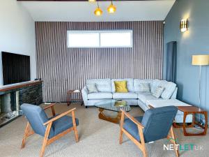 a living room with a couch and a table and chairs at Gannet's Lodge in Pembrokeshire