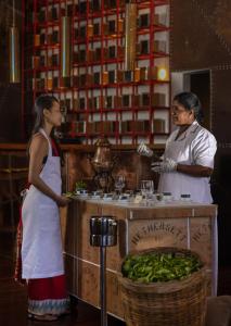 
a woman and a man standing in front of a counter filled with food at Heritance Tea Factory in Nuwara Eliya
