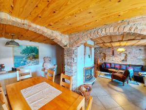 sala de estar con mesa y chimenea de piedra en Peter's Pine Cottage, en Korenica
