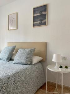 1 dormitorio con 1 cama y 1 mesa con lámpara en Estudio Malagueño Centro 1ºB, en Málaga
