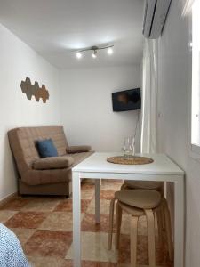 sala de estar con mesa blanca y sofá en Estudio Malagueño Centro 1ºB, en Málaga
