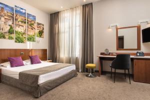 a hotel room with a bed and a desk at Forum Hotel Self Check-in Stara Zagora in Stara Zagora