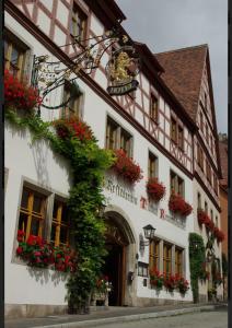 a building with flowers on the side of it at Tilman Riemenschneider in Rothenburg ob der Tauber