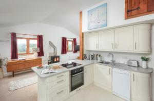a kitchen with white cabinets and a sink at The Hut in Bodmin