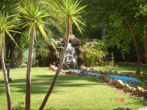 una fuente en medio de un patio con palmeras en Islantilla a 50 metros de la playa, en Islantilla