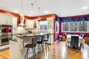 a kitchen with red walls and a table with bar stools at Mountain Oasis in Long Pond