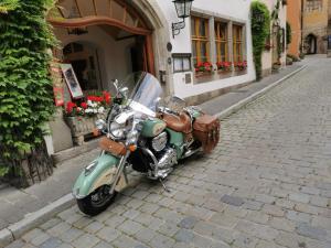a green motorcycle parked on the side of a street at Hotel Tilman Riemenschneider by ANS in Rothenburg ob der Tauber