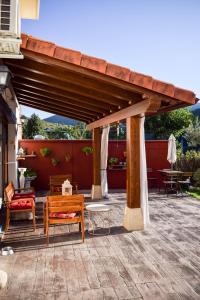 a wooden pergola with benches and tables on a patio at Naquela Castroviejo in Castroviejo