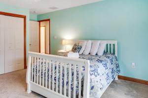 a white crib in a bedroom with a blue wall at Mountain Oasis in Long Pond