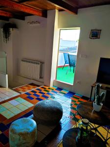 a living room with a room with a colorful floor at Casa Luzon, terraza-solarium con ducha y salon rustico in Villarejo de Salvanés
