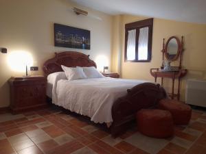 ein Schlafzimmer mit einem großen Bett, 2 Tischen und einem Spiegel in der Unterkunft APARTAMENTO SAN CARLOS in Baena