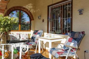 un patio con sillas, una mesa y una ventana en 003 Villa Muñeca - Deniasol, en Denia