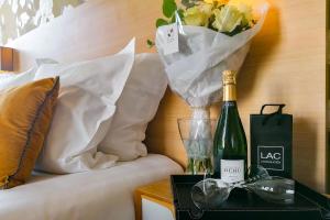 a bottle of champagne and a vase of flowers on a table at Ajoupa Aparthotel AMMI Massena in Nice