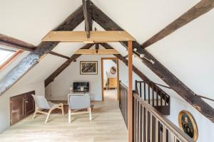d'une mezzanine avec un escalier et des poutres en bois. dans l'établissement LA LONGERE DU TERTRE - Charmante longère de 400m2 proche plage, à Cancale