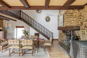 une salle à manger avec une table et une cheminée en pierre dans l'établissement LA LONGERE DU TERTRE - Charmante longère de 400m2 proche plage, à Cancale