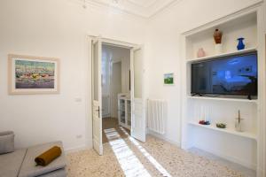 ein Wohnzimmer mit einem Flachbild-TV an der Wand in der Unterkunft VITTORIO EMANUELE HOUSE in Catania