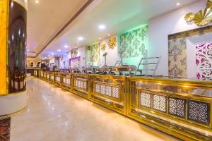 un restaurante con una larga fila de mesas en FabHotel Prime Z Grand, en Ludhiana