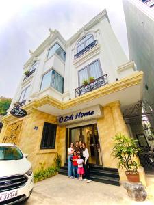 a family posing in front of a hotel at O Zoli Home in Ninh Binh