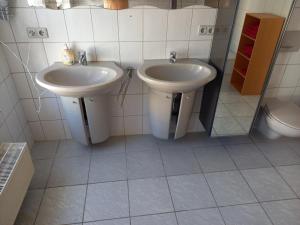 a bathroom with two sinks and a toilet at Ferienwohnung Lützowhaus in Lübeck