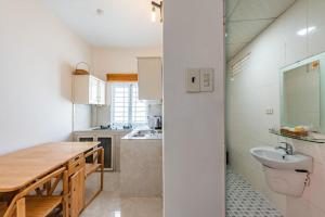 a kitchen with a wooden table and a sink at Suncosy Central Resort in Phú Quốc