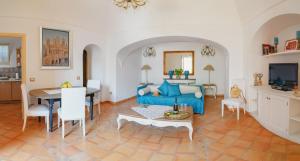 uma sala de estar com um sofá azul e uma mesa em Casa Teodora - Positano em Positano