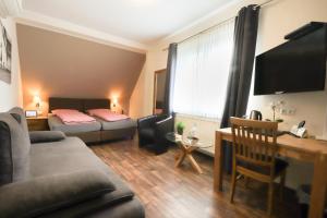 a living room with a couch and a bed at Hotel Am Dalwigker Tor in Korbach