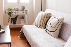 ein Sofa mit einem Kissen darauf im Wohnzimmer in der Unterkunft Calypso Apartment by Konnect, Corfu Old Town in Korfu-Stadt