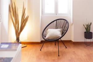 einen Stuhl mit Kissen in einem Zimmer mit Fenster in der Unterkunft Calypso Apartment by Konnect, Corfu Old Town in Korfu-Stadt