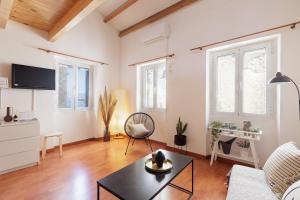 ein Wohnzimmer mit Sofa und Tisch in der Unterkunft Calypso Apartment by Konnect, Corfu Old Town in Korfu-Stadt