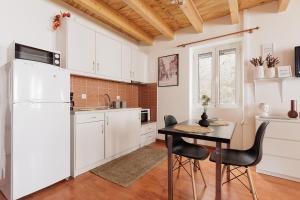 a kitchen with white cabinets and a table and chairs at Calypso Apartment by Konnect, Corfu Old Town in Corfu Town